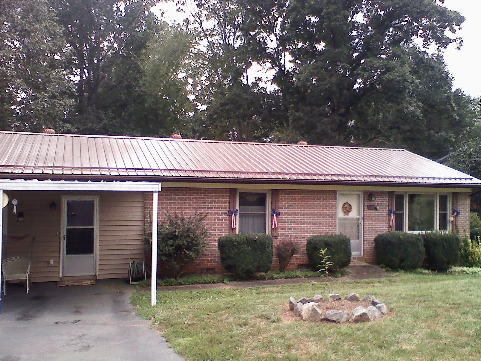 Bronze metal roof and carport on a brick ranch home — Roof Repair work by our crew in Kaibeto