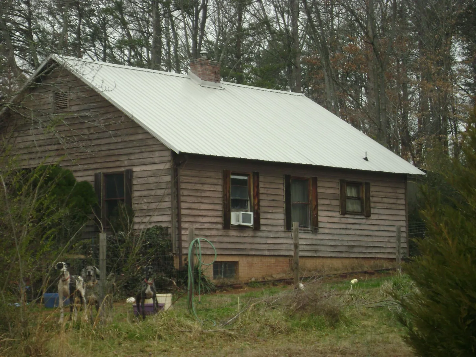 White metal roof on an old wood sided farmhouse, from a Metal Roof Installation job in Kaibeto